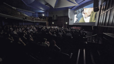 Audience watching a film in a dark theatre.