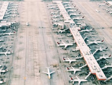 Aerial view of an airport with planes docked at gates.