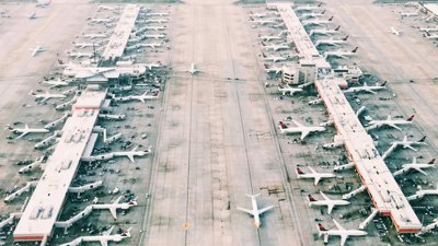 Aerial view of an airport with planes docked at gates.