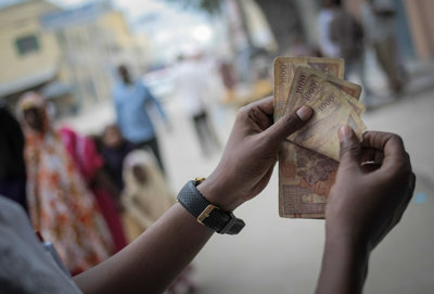 Two hands holding some notes and counting through them