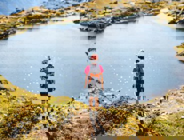 A person standing looking over a lake