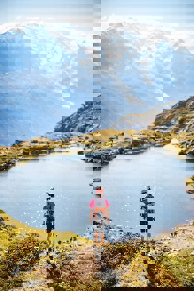 A person standing looking over a lake