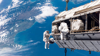 Two astronauts on a space walk from space shuttle.