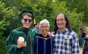 Three people on graduation day dressed for graduation. Laura Pulido stands in the middle.