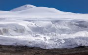 A wide, barren mountainous landscape covered in snow and ice.