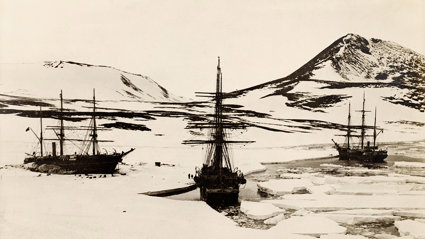 Old black and white photograph of three ships stuck in ice.