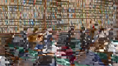 Researchers sat listening to conference talk in old library.