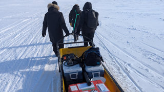The team pulling equipment along the snow