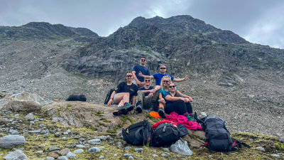Six explorers posing for a group photo on a mountain.
