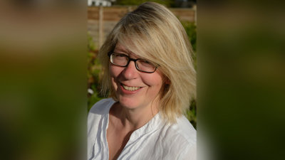 Portrait photo of Deborah Ireland against a blurred out background.
