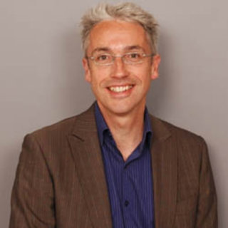 Headshot of Richard Phillips against a plain beige background.