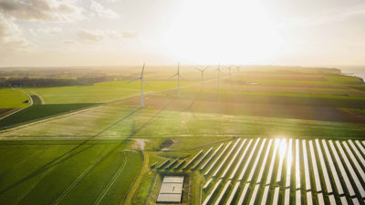 A wind farm surrounded by solar panels