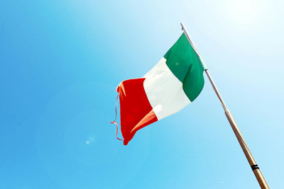 Italian flag of red, green and white on a background of blue sky