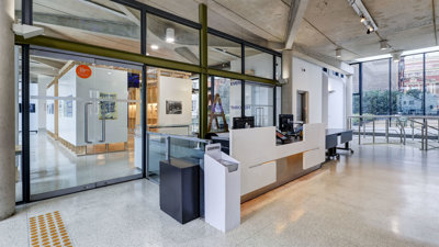 The main hall with reception desk and exhibition pavilion space at the Royal Geographical Society.