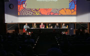 A panel of people sitting in a line in a lecture theatre.
