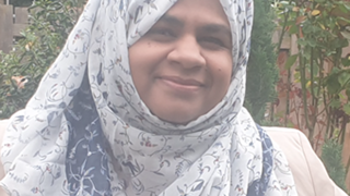 A picture of Iram Sammar, she is smiling and wearing a pretty headscarf.