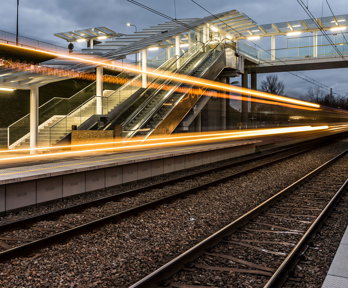 Long exposure photograph of train lights at a train station.