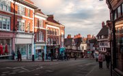A shopping high street showing shops and people.
