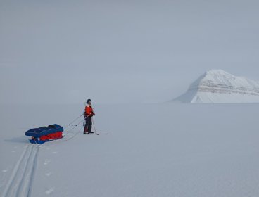 Heidi on skis on empty ice sheet in Svalbard.