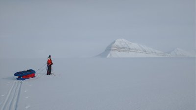Heidi on skis on empty ice sheet in Svalbard.