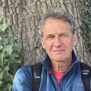 Paul Harris taking a photo of himself posing in front of a tree.