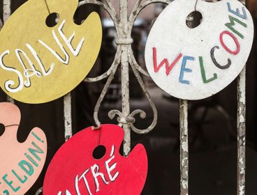 Wooden signs hanging from a metal gate.