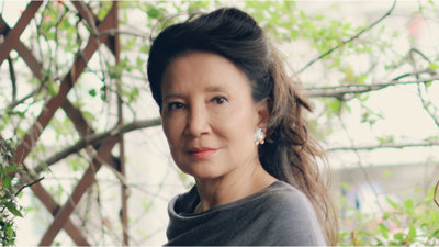 Headshot of author Jung Chan against backdrop of plants. 