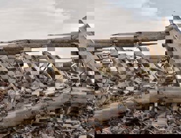 A pile of grey-brown rubble that was once a building, having been destroyed by an earthquake