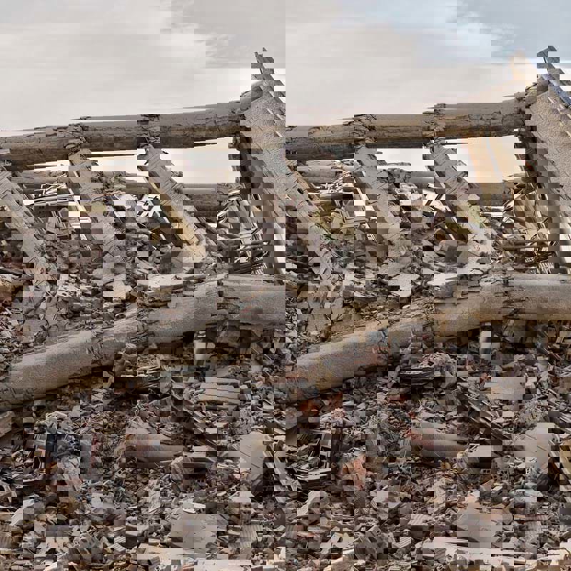 A pile of grey-brown rubble that was once a building, having been destroyed by an earthquake