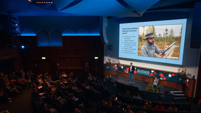 Speaker Tim Jacobs stood on stage in the Ondaatje Theatre at Explore 2022.  