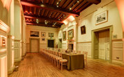 A formal banquet table set-up in a grand main hall with evening lighting. 