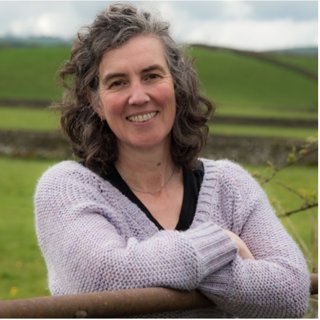 Headshot of Harriet Fraser taken in the countryside.