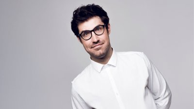 Dan Schreiber in front of plain background.