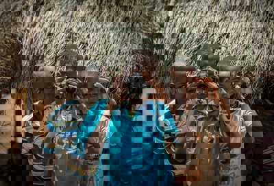 Three African children- one is pointing a camera at the person taking the picture