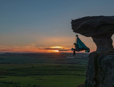 Extreme sleeper dangled off cliff edge during sunset.