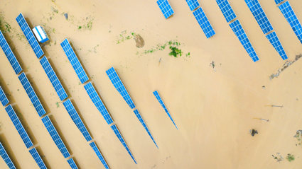 Tops of solar panels sticking out of the water in a flooded area.