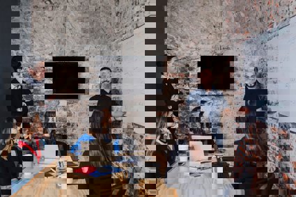 People sat around a table looking at a person presenting a workshop