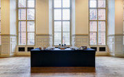 A catering station with tea and coffee set-up in a grand main hall. 