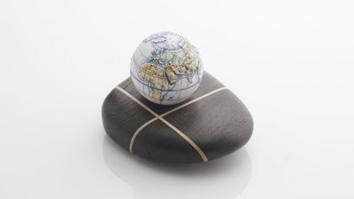Porcelain globe on top of a dark bog oak.