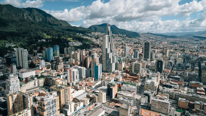 Highrise view of a city, with mountains in the background. 