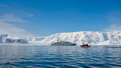 Luxury cruise ship and a small EV boat with passengers in an arctic region next to a glacier.