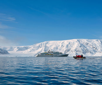 Luxury cruise ship and a small EV boat with passengers in an arctic region next to a glacier. 