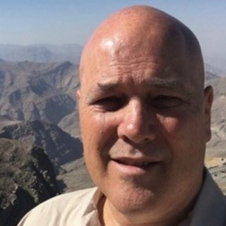 Mark Hutchings in front of mountainous background.