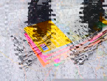 A pile of Ordnance Survey maps and a camera on top of a map