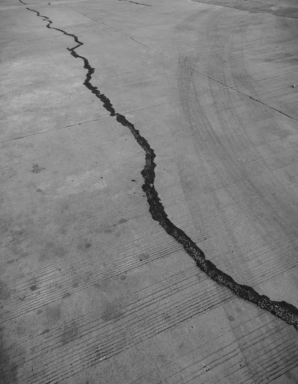Greyscale photo of crack in concrete