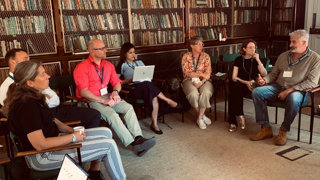 A group of people sit together on chairs as part of a workshop at the Society