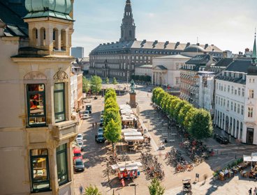 City of Copenhagen showing trees, a street market and racks of bicycles.