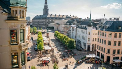 City of Copenhagen showing trees, a street market and racks of bicycles.