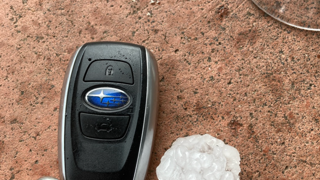 Image of car keys on table next to a glass