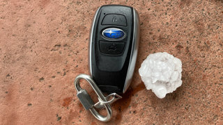 Car keys laid next to a large hailstone for size comparison.